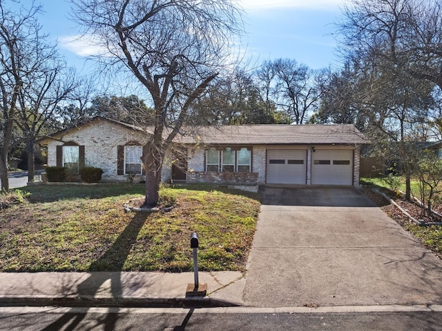 ranch-style home with an attached garage, a front lawn, concrete driveway, and brick siding