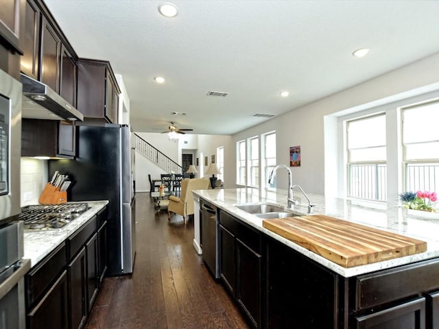 kitchen with stainless steel appliances, visible vents, open floor plan, a kitchen island with sink, and a sink