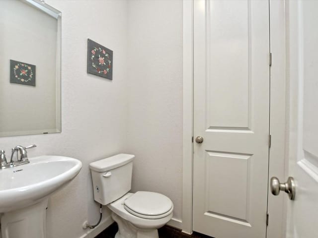 bathroom featuring a sink, toilet, and baseboards