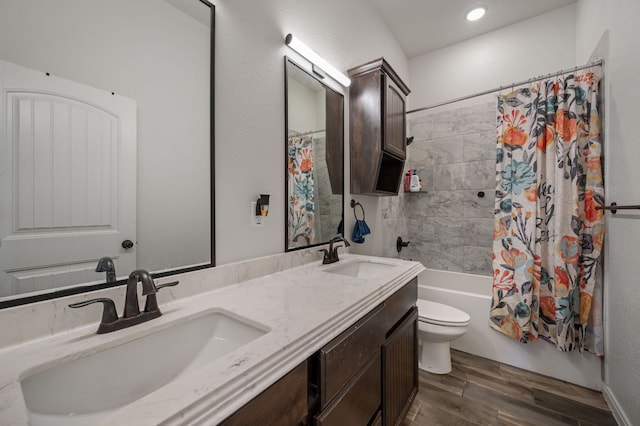 full bathroom with shower / tub combo, a sink, toilet, and wood finished floors