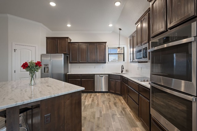 kitchen featuring hanging light fixtures, tasteful backsplash, stainless steel appliances, and dark brown cabinets