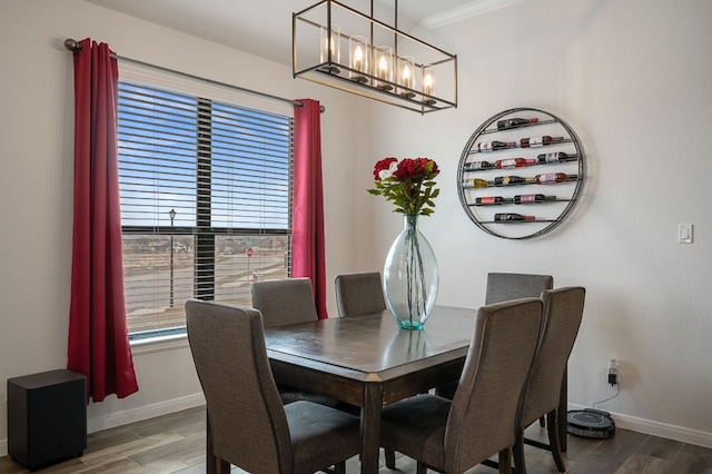 dining space with baseboards, wood finished floors, and ornamental molding