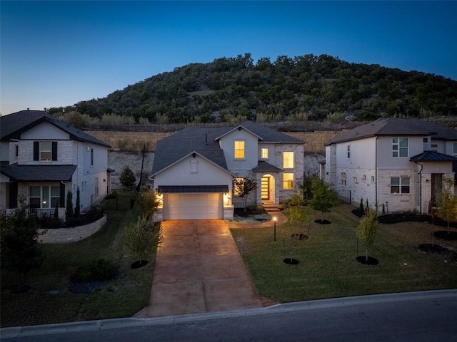 219 Baldovino Skwy, Lakeway, TX 78738 - traditional home featuring driveway, a garage, stone siding, a front yard, and a mountain view