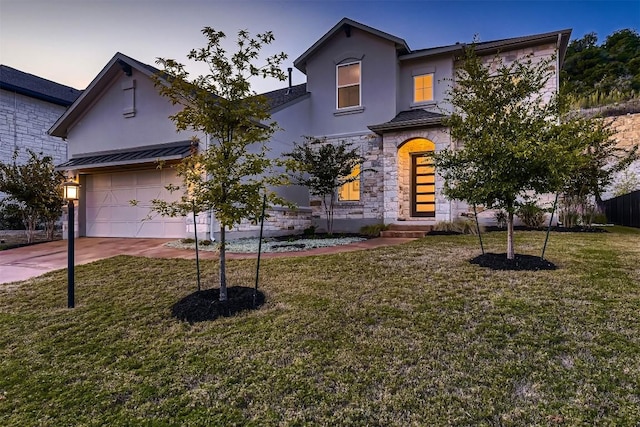 traditional-style house featuring a garage, concrete driveway, stone siding, stucco siding, and a front lawn