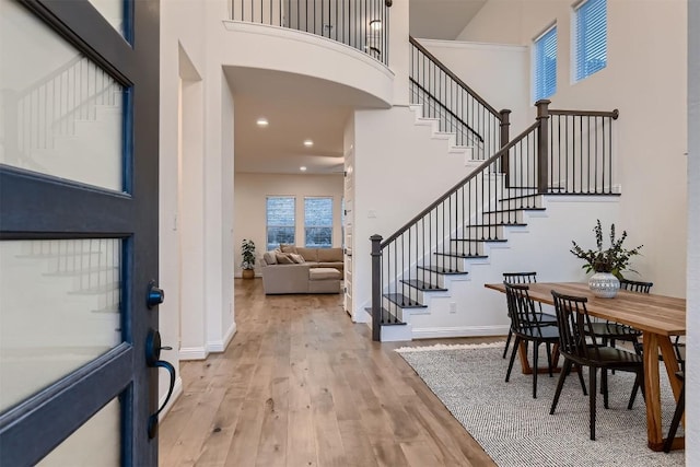 entrance foyer with a high ceiling, wood finished floors, and baseboards