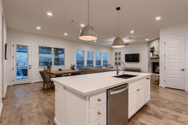 219 Baldovino Skwy, Lakeway, TX 78738 - kitchen with stainless steel dishwasher, open floor plan, recessed lighting, light wood-type flooring, and light countertops
