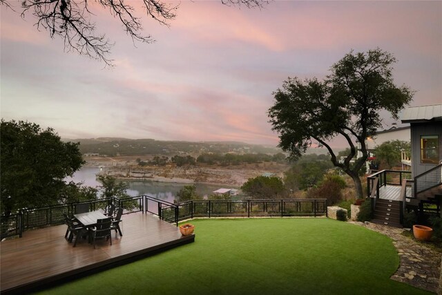 19745 Lakehurst Loop, Spicewood, TX 78669 - yard at dusk featuring a deck with water view, stairs, and a yard