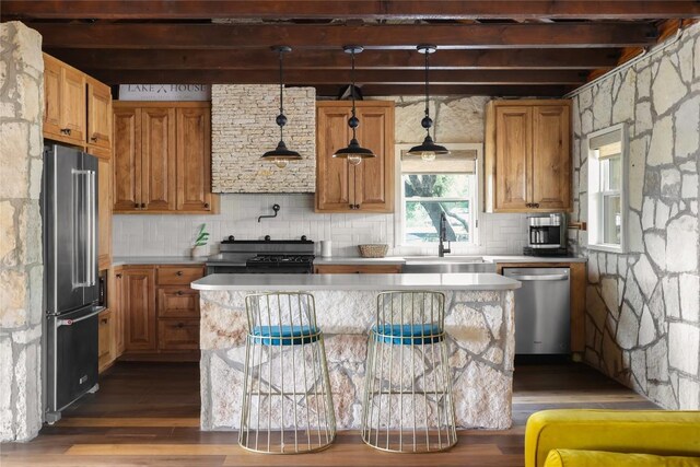 19745 Lakehurst Loop, Spicewood, TX 78669 - kitchen featuring appliances with stainless steel finishes, wood finished floors, beamed ceiling, light countertops, and backsplash
