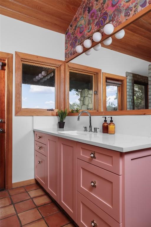 19745 Lakehurst Loop, Spicewood, TX 78669 - bathroom with wooden ceiling, a sink, baseboards, tile patterned floors, and healthy amount of natural light