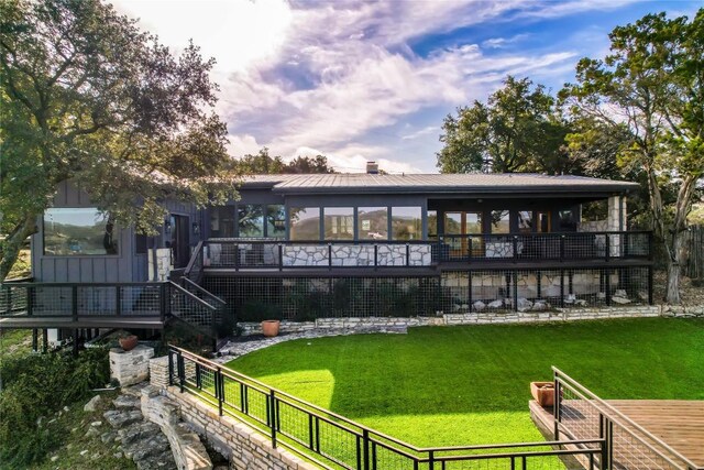 19745 Lakehurst Loop, Spicewood, TX 78669 - back of property featuring a sunroom, a wooden deck, and board and batten siding