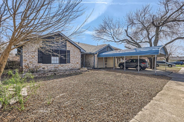 view of front of house featuring a carport, stone siding, and driveway