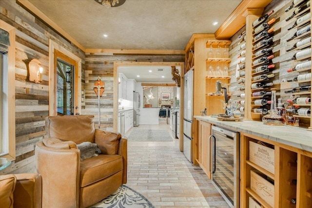 1920 River Rd, Wimberley, TX 78676 - wine cellar featuring wine cooler, ornamental molding, brick flooring, wood walls, and recessed lighting