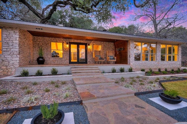 1920 River Rd, Wimberley, TX 78676 - doorway to property featuring stone siding and a porch