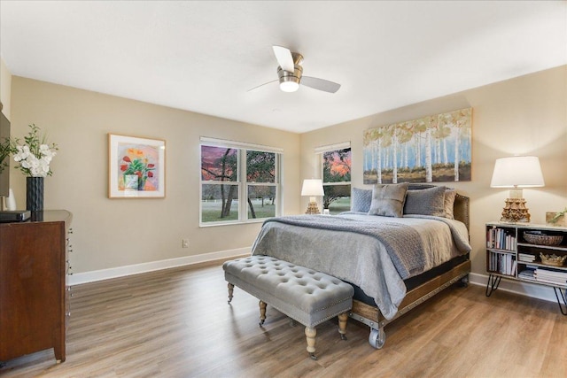 1920 River Rd, Wimberley, TX 78676 - bedroom featuring baseboards, wood finished floors, and a ceiling fan