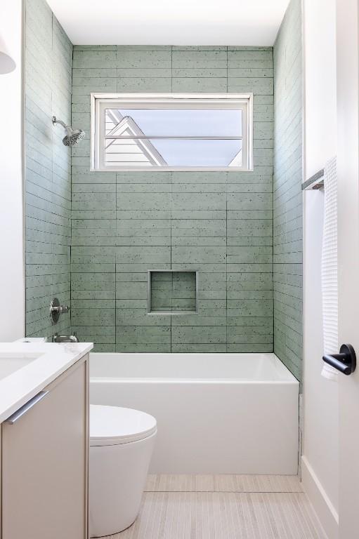 bathroom with washtub / shower combination, vanity, and toilet