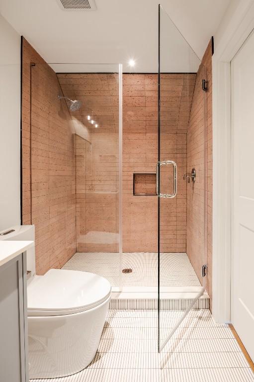 full bathroom featuring visible vents, toilet, tile patterned floors, vanity, and a shower stall