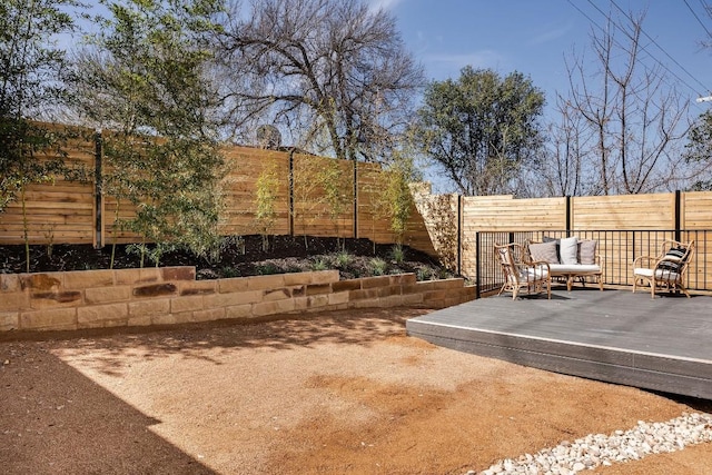 view of yard with a wooden deck, a fenced backyard, and an outdoor living space