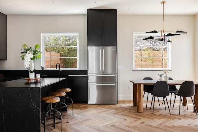 kitchen with dark countertops, modern cabinets, dark cabinets, and freestanding refrigerator