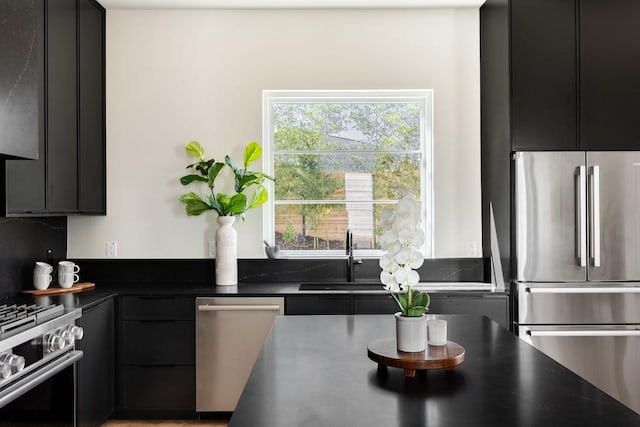 kitchen with appliances with stainless steel finishes, dark countertops, and dark cabinetry