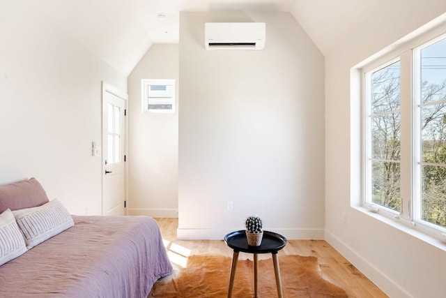 bedroom featuring a wall mounted air conditioner, vaulted ceiling, baseboards, and multiple windows