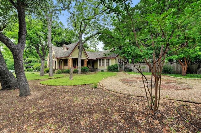 view of front of home with brick siding, a front lawn, and fence