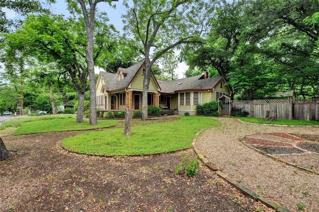 rear view of property featuring a yard, brick siding, and fence