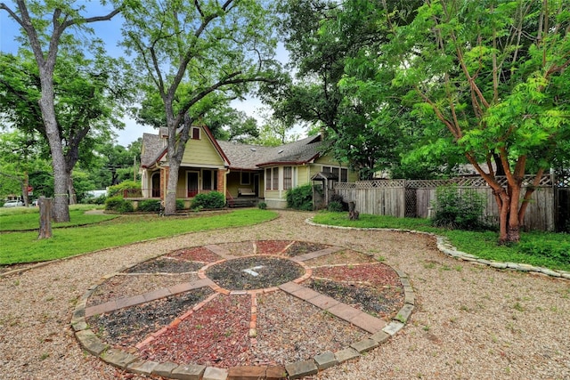 rear view of property featuring a yard, brick siding, and fence