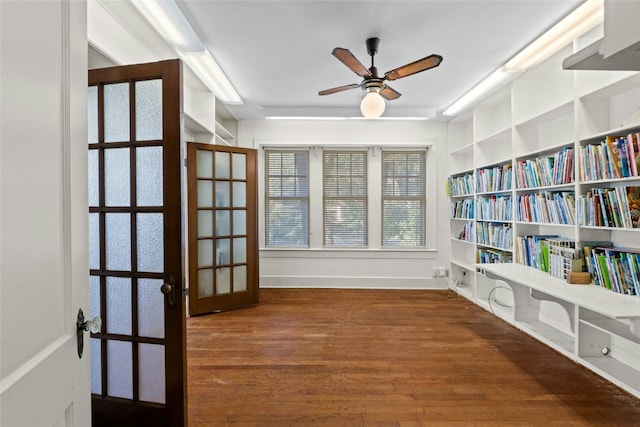 sitting room featuring dark wood-style floors, built in features, french doors, a ceiling fan, and baseboards