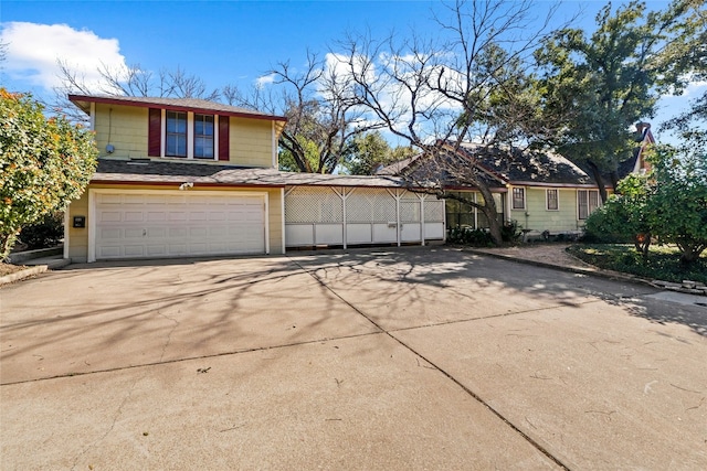 view of front facade with a garage, a shingled roof, and concrete driveway