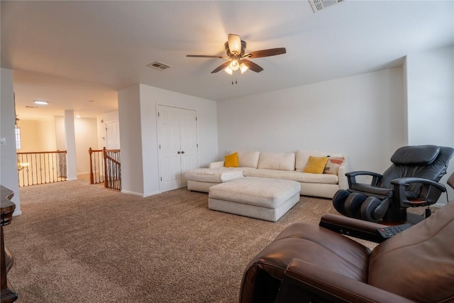 living area with a ceiling fan, light colored carpet, visible vents, and baseboards