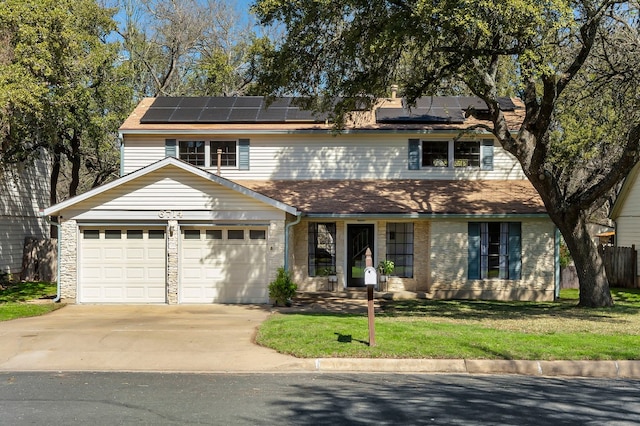 traditional home with a front lawn, driveway, an attached garage, and solar panels