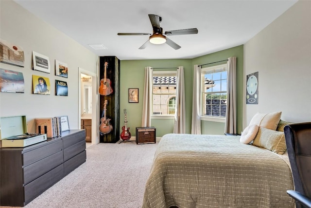 bedroom featuring a ceiling fan, light carpet, and ensuite bathroom