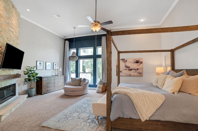 carpeted bedroom featuring visible vents, a towering ceiling, ceiling fan, crown molding, and a stone fireplace