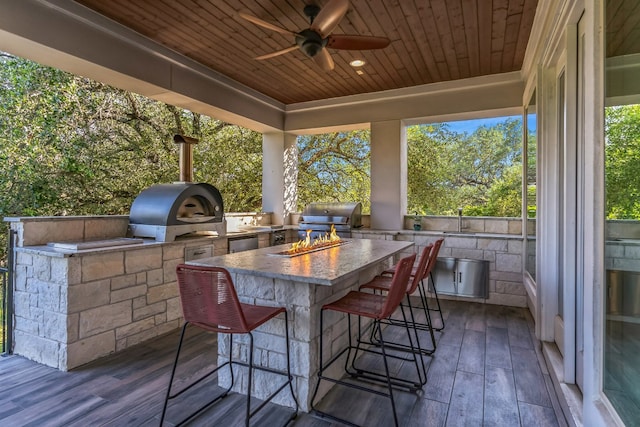 exterior space with ceiling fan, a grill, outdoor wet bar, and area for grilling