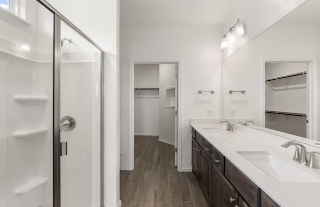 113 Crossbar St, Georgetown, TX 78633 - full bath featuring a shower stall, wood finished floors, double vanity, baseboards, and a walk in closet