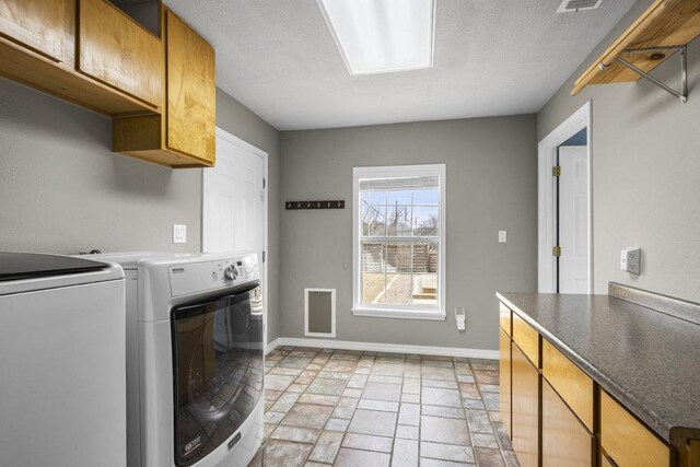 911 Sandy Mountain Dr, Sunrise Beach, TX 78643 - washroom with stone tile floors, washer and clothes dryer, cabinet space, and baseboards