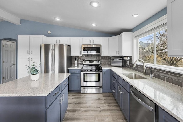 911 Sandy Mountain Dr, Sunrise Beach, TX 78643 - kitchen featuring stainless steel appliances, a sink, white cabinetry, light wood-style floors, and blue cabinetry