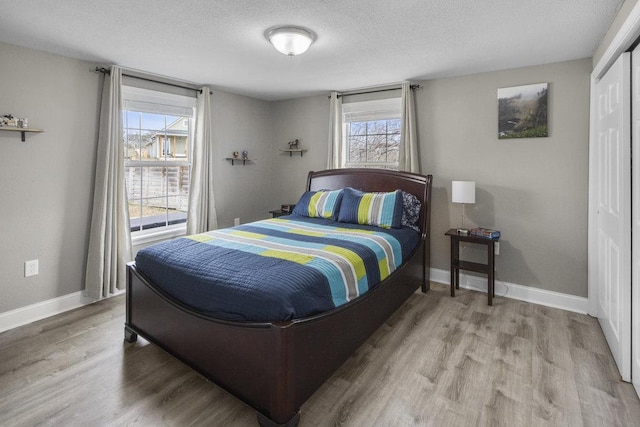 911 Sandy Mountain Dr, Sunrise Beach, TX 78643 - bedroom featuring wood finished floors, baseboards, a textured ceiling, and a closet