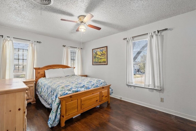 bedroom featuring dark wood-type flooring, a textured ceiling, baseboards, and a ceiling fan