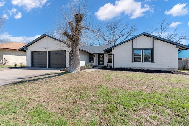 mid-century modern home featuring a garage, concrete driveway, brick siding, and a front yard