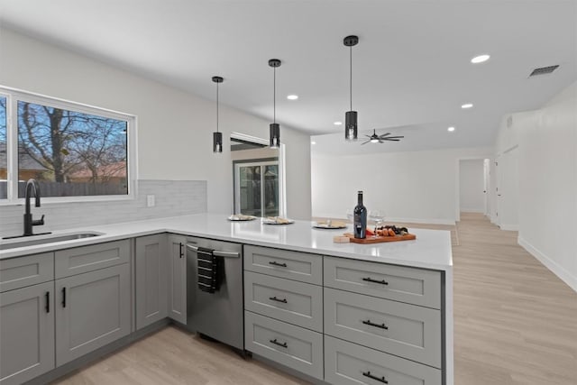 10505 Parkfield Dr, Austin, TX 78758 - kitchen with a sink, light wood-style floors, gray cabinets, dishwasher, and a peninsula