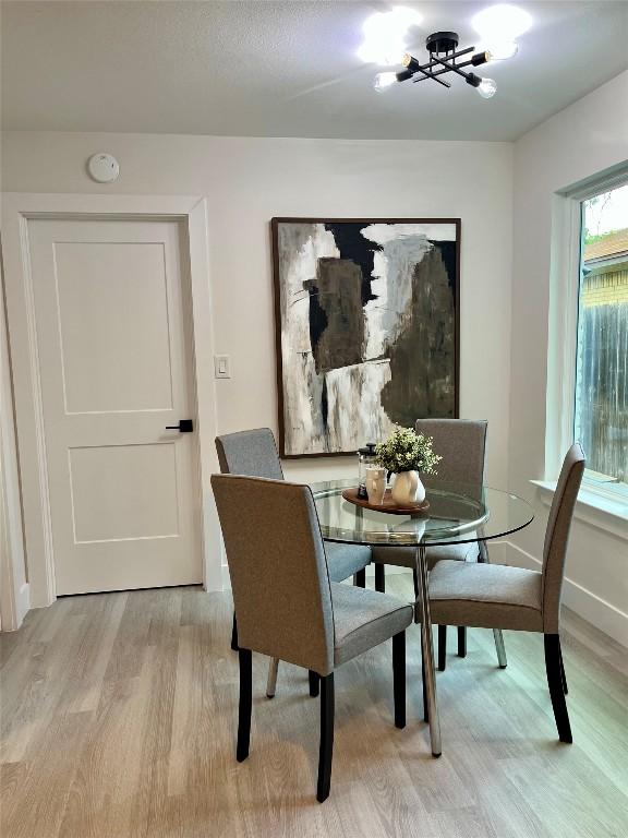 10505 Parkfield Dr, Austin, TX 78758 - dining room with baseboards, a chandelier, and light wood-style flooring