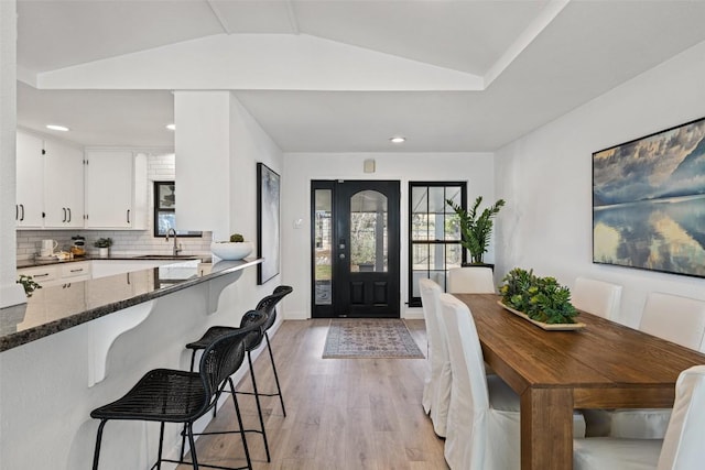 entrance foyer with recessed lighting, vaulted ceiling, and light wood-style flooring