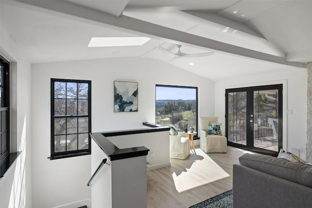 interior space with light wood finished floors, ceiling fan, lofted ceiling with skylight, and french doors