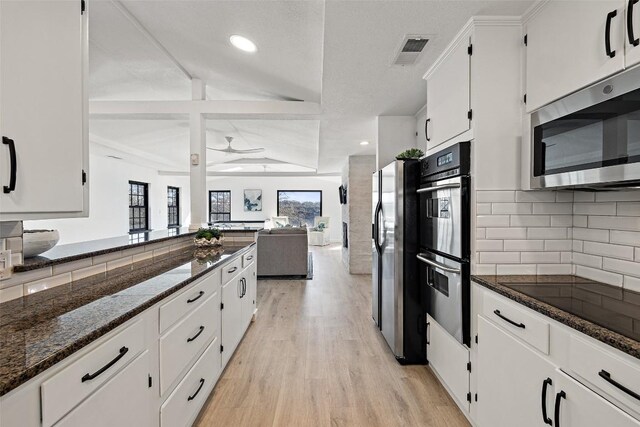 1201 Lake Shore Dr, Spicewood, TX 78669 - kitchen featuring stainless steel appliances, dark stone countertops, white cabinets, tasteful backsplash, and light wood-style flooring