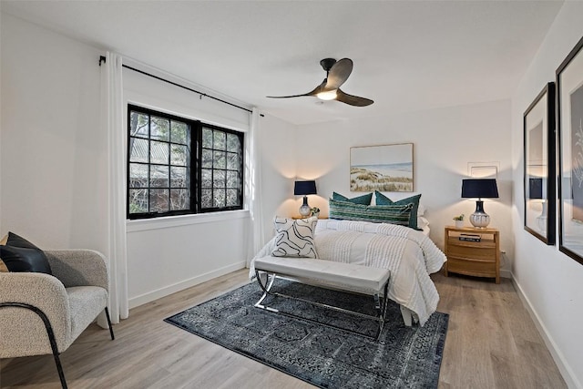 bedroom with light wood-style flooring, baseboards, and a ceiling fan