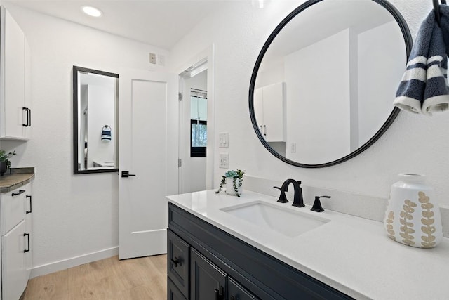 bathroom featuring vanity, baseboards, and wood finished floors