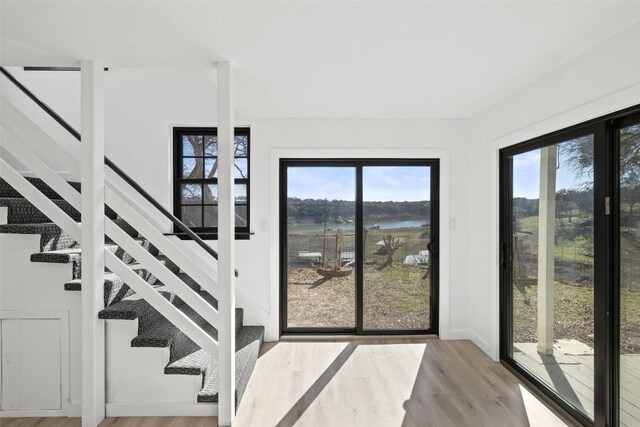 1201 Lake Shore Dr, Spicewood, TX 78669 - stairs featuring plenty of natural light, wood finished floors, and a water view