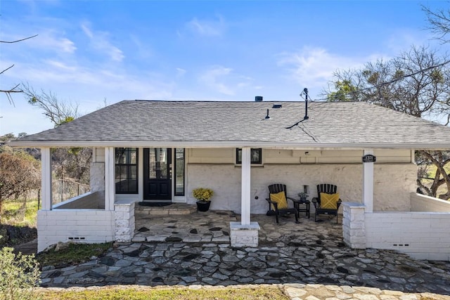 rear view of house with roof with shingles