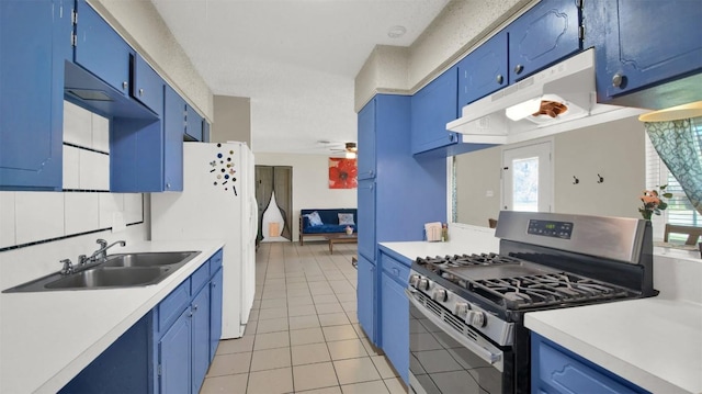 kitchen with under cabinet range hood, stainless steel gas range oven, and light countertops